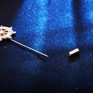 Detailed close-up shot of the gold-tone rhinestone ship wheel lapel pin with long pin and cap.