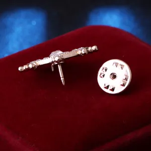 Rose gold tone ship wheel lapel pin detail shot showing textured metal and secure back.