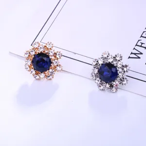 Elegant crystal flower brooch pin with deep blue center stone, perfect suit accessory.