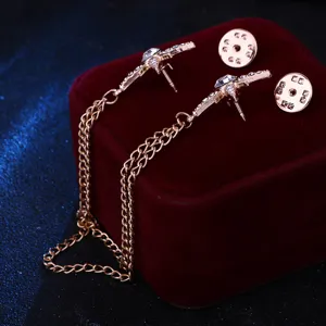 Exquisite rose gold starburst collar pin set with sparkling crystals and chains.