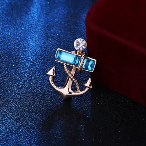 Exquisite nautical anchor brooch detail, featuring blue crystal gems and polished rose gold metal.