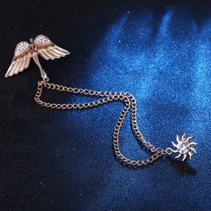 Vista detallada de broche con cadena, alas de ángel y sol dorados, accesorio de solapa metal.