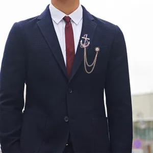 Vista detallada del broche de cadena ancla y borla en traje marino, elegante accesorio hombre