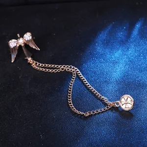 Vue détaillée de la broche homme or rose avec ailes d'ange en strass, double chaîne et croix.