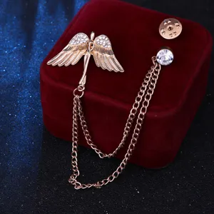 Detalle del exquisito broche de alas de ángel con diamantes de imitación y cadenas dobles.