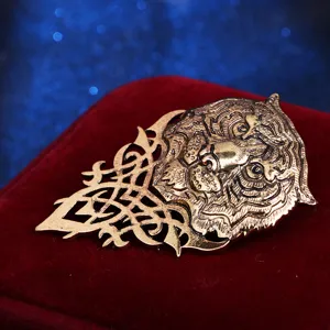 Vintage gold tiger head brooch detail shot, intricate filigree metal craftsmanship accessory.