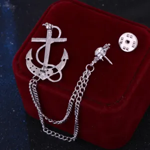 Vista detallada de un broche de ancla de plata con cadena, accesorio versátil para traje formal.