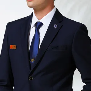 Detail view of men's naval style ship steering wheel brooch and suit collar accessories.