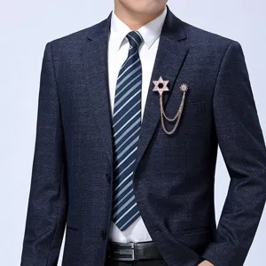 Vista detallada de un elegante broche de hexagrama en oro rosa con cadenas de flecos para hombre.