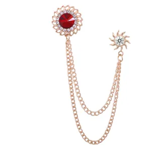 Detailed view of vintage rose gold double chain brooch with red crystal and dazzling rhinestones.