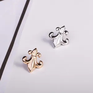 Metal fleur-de-lis brooch pins set in gold and silver, vintage style suit collar accessories.