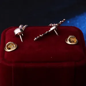 Vintage eland broche detail met metalen speld en kwastketting op fluwelen doos.