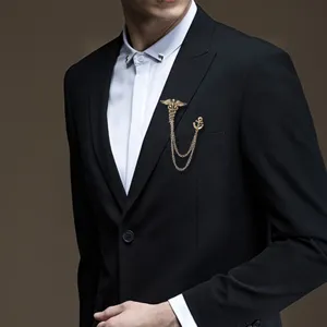 Detailed view of men vintage brooch with caduceus and anchor chain design for suit.