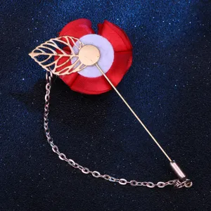 Nahaufnahme einer roten Stoffblume Anstecknadel mit goldenem Blatt und Kette.