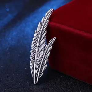 Detailed shot of vintage silver feather brooch accessory showing fine texture design