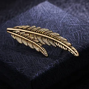Vintage gold feather brooch detail shot, perfect suit accessory for men and women fashion.