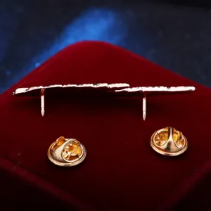Close-up view of retro feather brooch back with double pins and secure metal clasps detail.