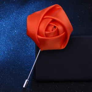 Detailaufnahme der orangen Stoffrosenbrosche, elegantes Revers-Accessoire für Anzüge.
