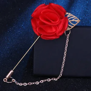 Detailaufnahme einer roten Stoffrosen Anstecknadel mit goldenem Blatt und filigraner Kette.
