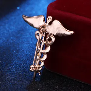 Close-up detail of the gold caduceus medical symbol brooch back pin with wings design.