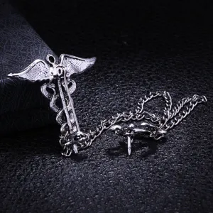 Vintage silver caduceus wings brooch with chain lapel pin for men fashion accessory.