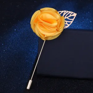 Gelbe Stoff-Rosen-Anstecknadel im Detail, elegante goldene Metallblatt- und Stiel-Broche für Anzug.
