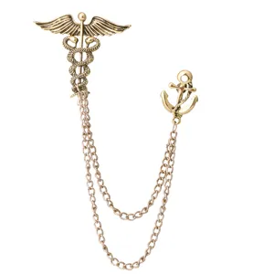 Retro double chain brooch featuring caduceus and anchor design, vintage gold-tone metal detail.