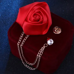 Detailansicht der eleganten roten Stoffrosen-Brosche mit Quastenkette und Kristall für Anzüge.