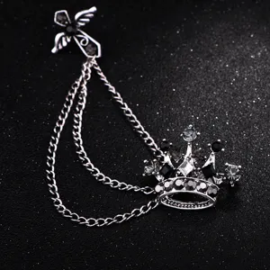 Primo piano dettagliato della spilla catena corona argento vintage con strass neri lucidi.
