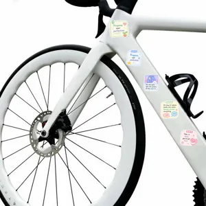 Primo piano di adesivi estetici con citazioni curative su un telaio di bicicletta bianco.