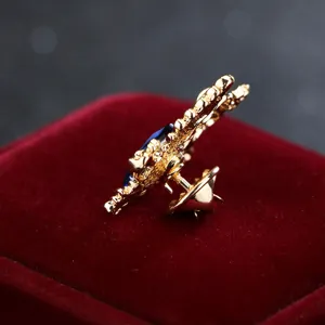 Nahaufnahme der Vintage Doppeladler Brosche mit blauem Stein, edle Metallnadel.