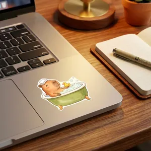 Close-up detail of cute capybara bathtub sticker on laptop, waterproof cartoon aesthetic decal.
