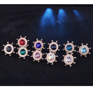 Close-up view of multiple colorful rhinestone ship wheel collar pins, metallic texture detail.