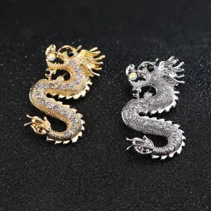 Primo piano dettagliato di eleganti spille a drago in strass color oro e argento.