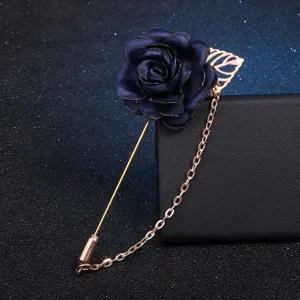 Dark blue fabric rose lapel pin detail, gold stick pin and tassel chain accessory.