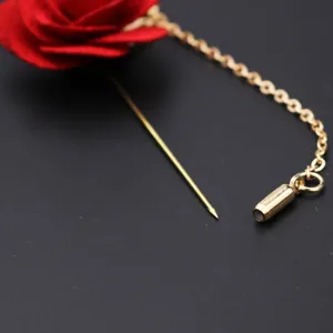 Nahaufnahme der roten Stoffrosen-Brosche mit langem Goldstift und Zierkette detail.