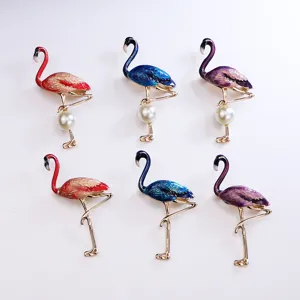 Closeup of enamel flamingo brooch, metal alloy jewelry details, colorful animal fashion pins.