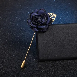 Exquisite dark blue fabric camellia brooch with gold pin and leaf, perfect apparel detail.