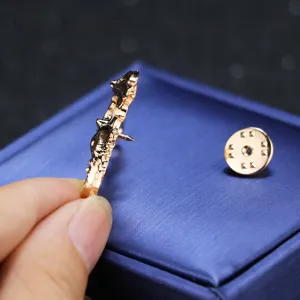 Detail view of the exquisite golden dragon brooch pin, showing its side profile and secure backing.