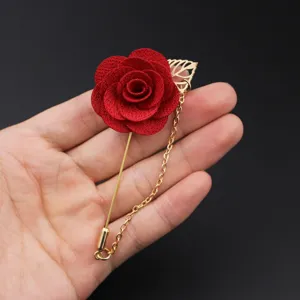 Detailaufnahme der roten Stoffrosen-Anstecknadel mit zarten Blütenblättern und goldener Kette.