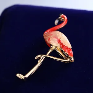 Exquisite enamel flamingo brooch detail view, crafted in shiny gold tone metal alloy.