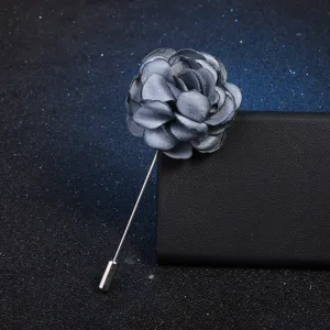 Gros plan détaillé d'une broche fleur en tissu gris avec longue épingle métal, chic.