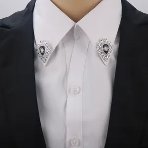 Nahaufnahme der detaillierten Vintage silbernen Kragennadeln mit eleganten dunklen Edelsteinen.