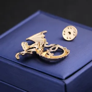 Close-up back detail of gold dragon brooch with secure pin clutch on blue jewelry box