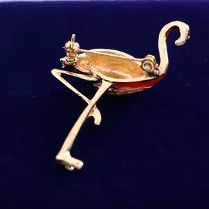 Detailed view of gold-tone flamingo brooch back pin mechanism, elegant alloy jewelry accessory.