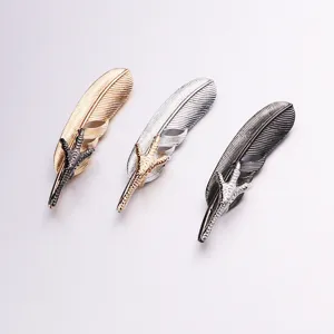 Detailed shot of vintage metal feather brooches with eagle claw design for suits.