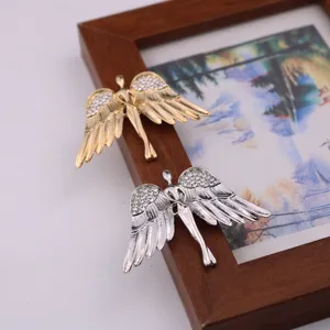 Vista detallada de broche elegante alas de ángel con diamantes de imitación, insignia vintage.