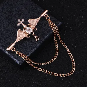 Gros plan détail broche rétro or rose ailes d'ange croix avec chaînes de strass brillantes.
