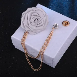 Handgemachte Stoffrosen Brosche mit eleganter hängender Strasskette für Hochzeitsanzug Accessoire Detail.