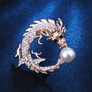 Primo piano dettagliato della spilla drago in strass scintillante con dettaglio di perla.